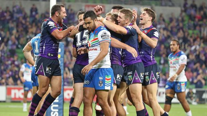 Christian Welch of the Melbourne Storm is congratulated by his teammates after scoring a try as Peta Hiku of the Warriors looks on (Photo / Getty Images)