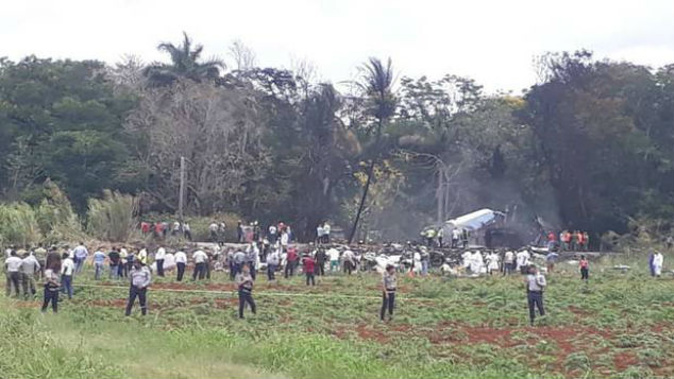 Rescue and search workers on the site where a Cuban airliner with 104 passengers on board plummeted into a yuca field. (Photo: AP)