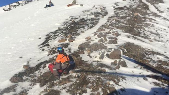 A Land Search and Rescue volunteer uses an ice axe and crampons to work his way across to a young Austrian woman stranded just below Red Crater. The woman's companion fell 100m after slipping on.