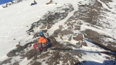 A Land Search and Rescue volunteer uses an ice axe and crampons to work his way across to a young Austrian woman stranded just below Red Crater. The woman's companion fell 100m after slipping on.
