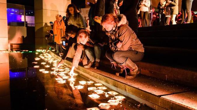 Candles are lit and placed in the water to remember lost loved ones. Photo / Kate Whitley, Te Papa.