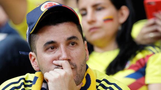 A Colombian fan reacts after his team's 2-1 loss to Japan. (Photo / AP)