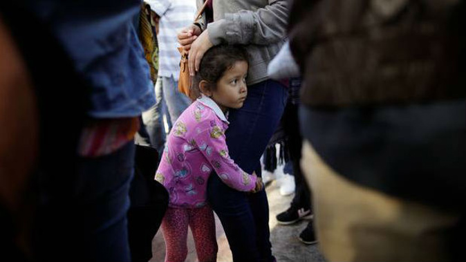 Nicole Hernandez, of the Mexican state of Guerrero, holds on to her mother as they wait with other families to request political asylum in the United States. Photo / AP