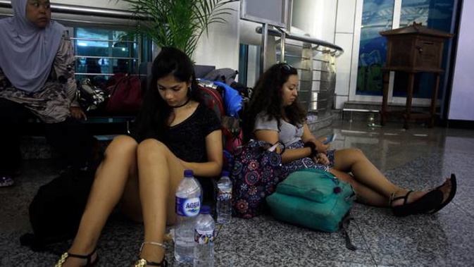 Passengers wait at Bali's international airport after travel was disrupted by Mt Agung. Photo / AP