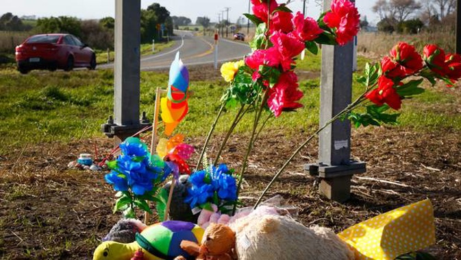 Flowers and toys are being placed on the side of the road at the site of where the crash happened. (Photo / NZ Herald)