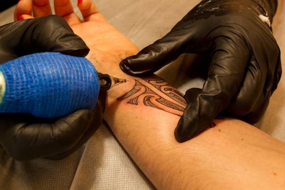 Tā moko artist Jacob Tautari works on the tattoo. Photo/Ben Fraser