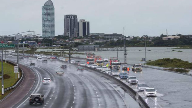 High tides and bad weather closed part of Auckland's motorway in January and NZTA is warning it could happen again tomorrow. (Photo / NZ Herald)