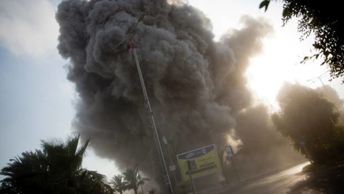 Smoke rises in the background as an Israeli air strike hits a governmental building in Gaza City. (Photo / AP)