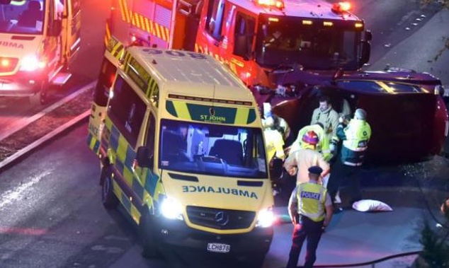 St John Ambulance officers, firefighters and police join forces to help at the scene of a fatal car crash in Stuart St, Dunedin, yesterday. (Photo / Otago Daily Times)