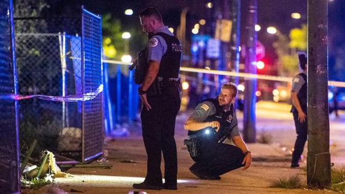 Police investigate the scene where multiple people were shot in Chicago. Photo / AP