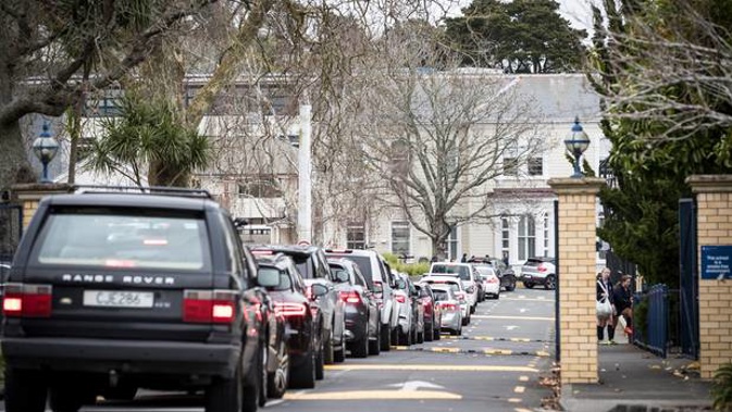 Parents in their vehicles line up to collect their children at Diocesan School for Girls. Photo / Michael Craig