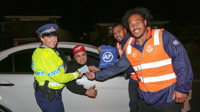 Police officer Gabrielle Griffiths hands out free tickets to the Warriors' next home game to motorist Kuki Ionatana, with Warriors Sam Lisone and Agnatius Paasi. (Photo / Chris Loufte)