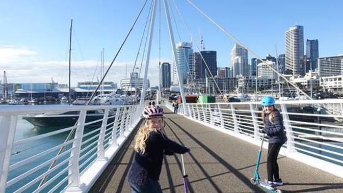 Emma, left, and Amy Gernhoefer may get to ride their scooters along the Auckland waterfront tomorrow instead of going to school. Photo / Carol Gernhoeferr