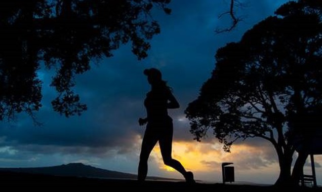 As the sun rises, runners compete in the North Shore Marathon on Sunday morning. Photo / Brett Phibbs
