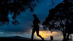 As the sun rises, runners compete in the North Shore Marathon on Sunday morning. Photo / Brett Phibbs