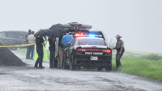 Law enforcement officers gather near the scene where the body of a woman was found near Interstate 35 north of Laredo, Texas. She was one of four women killed in 10 days. (Photo / AP)