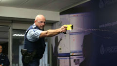 Sergeant Darrin Putt demonstrating the use of a taser during Police National Headquarters. (Photo: Mark Mitchell)