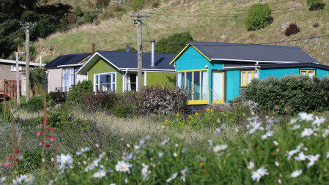 The iconic beachside baches in Taylors Mistake.