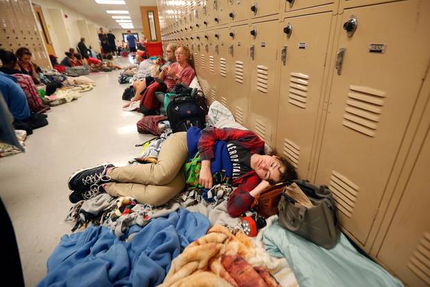 Emily Hindle lies on the floor at an evacuation shelter set up at Rutherford High School, in advance of Hurricane Michael. Photo / AP