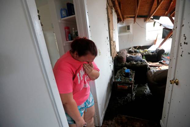 Kaylee O'Brian weeps inside her home after several trees fell on it during Hurricane Michael in Panama City, Florida. Photo / AP
