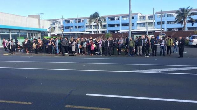 Passengers queue for the bus at Morningside after services were cancelled along the Western Line. (Photo / NZ Herald)