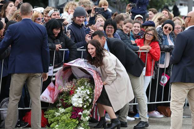 Jacinda Ardern struggles under the weight of a huge bouquet of flowers for Meghan Markle yesterday. (Photo / Getty)