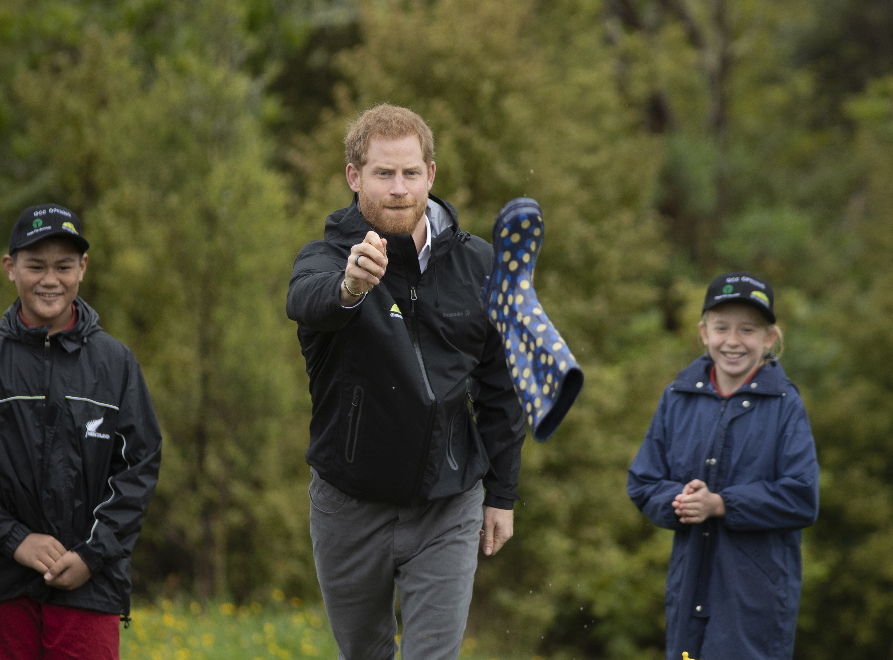 Prince Harry, Duke of Sussex reacts during the gumboot throwing competition after unveiling a plaque after dedicating 20 hectares of native bush to the Queen's Commonwealth Canopy project. Photo / Getty Images