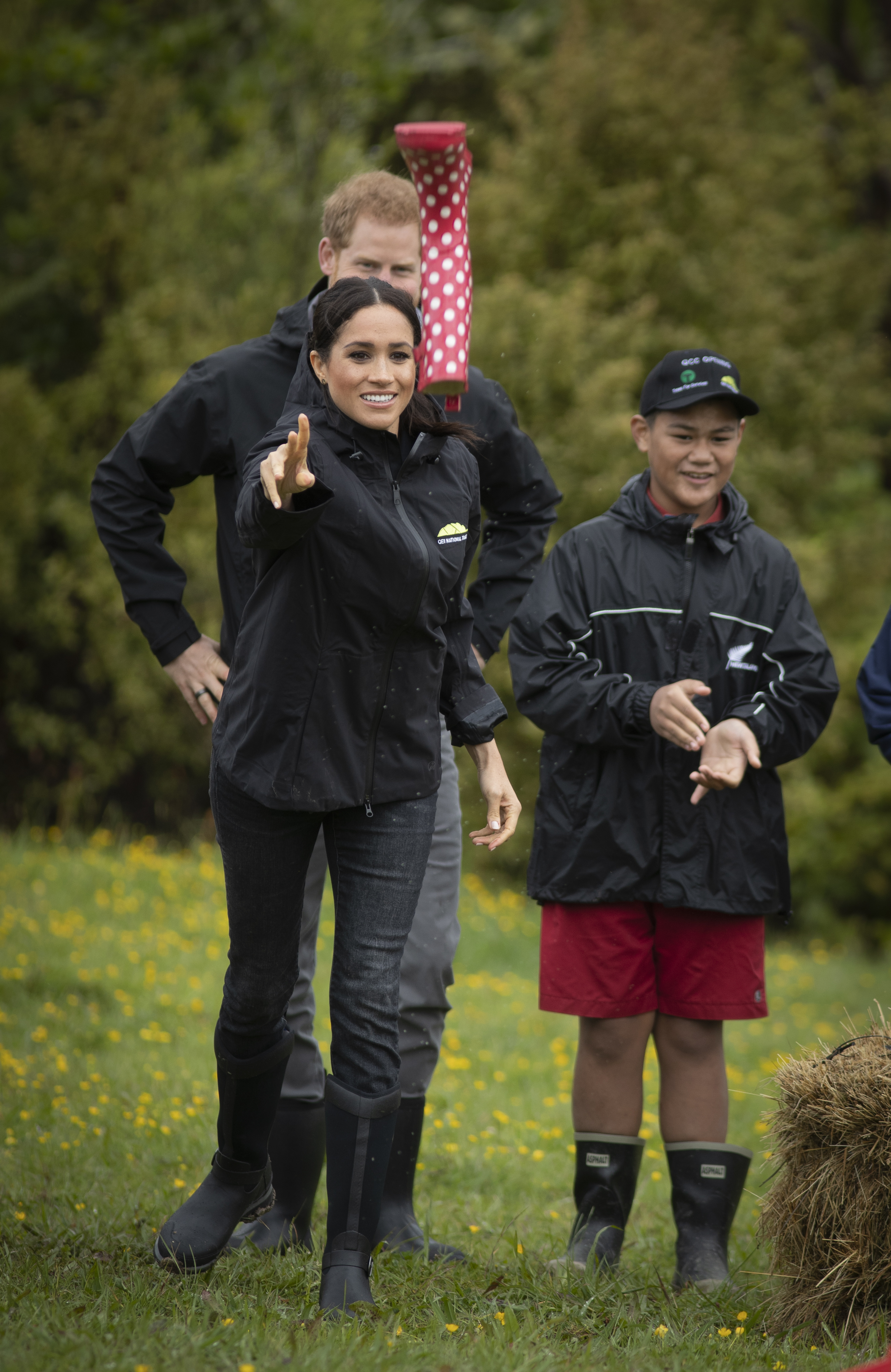 Prince Harry, Duke of Sussex and Meghan, Duchess of Sussex react during their gumboot throwing competition after unveiling a plaque after dedicating 20 hectares of native bush to the Queen's Commonwealth Canopy project. Photo / Getty Images