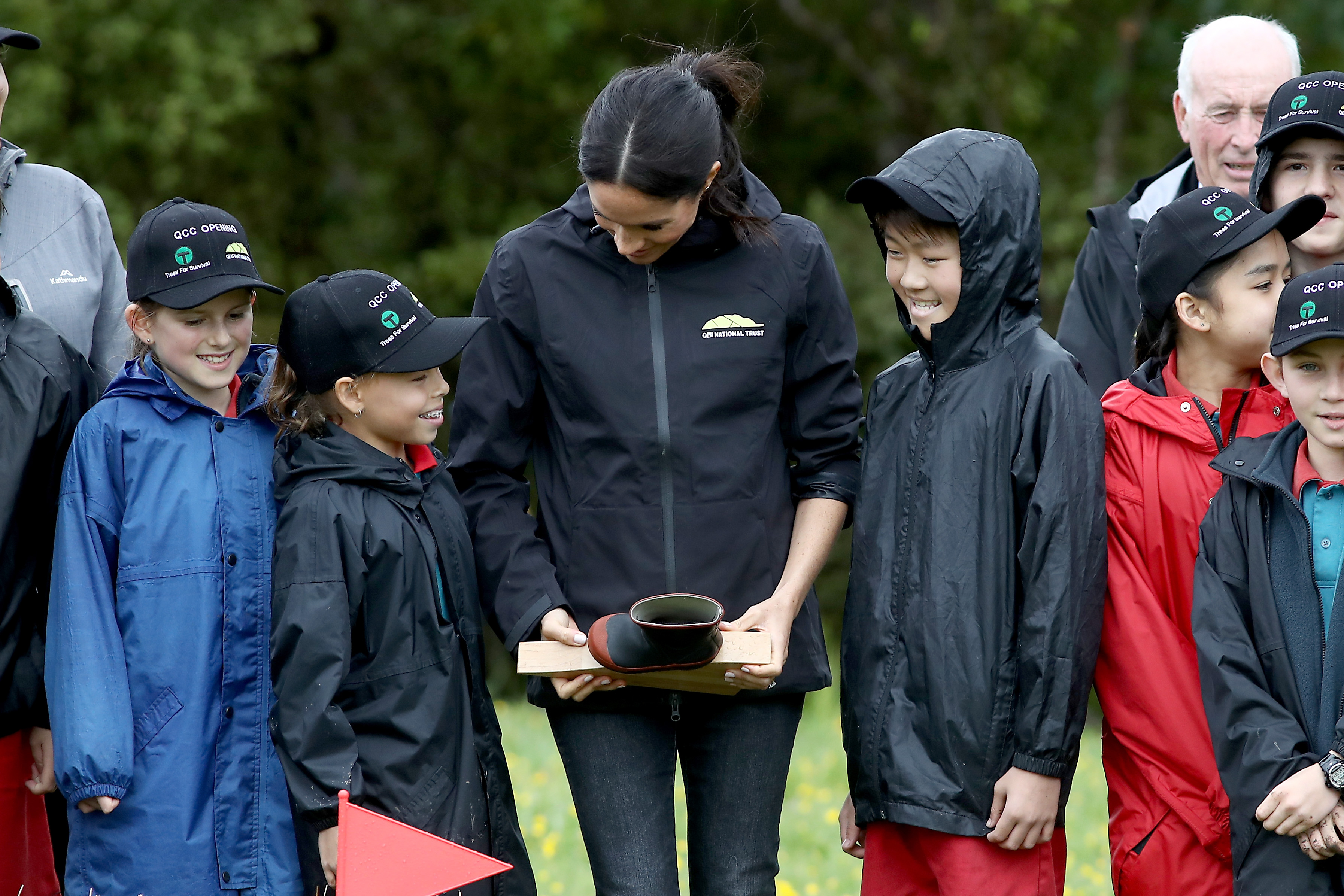 Meghan, Duchess of Sussex speaks with children and holds her prize in the gumboot throwing competition as they attend the unveiling of The Queen's Commonwealth Canopy in Redvale on October 30, 2018 in Auckland, New Zealand. Photo / Getty Images