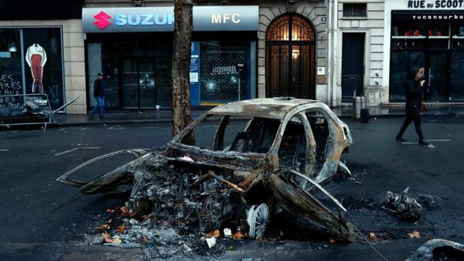 A charred car is pictured the day after a demonstration, near the Arc de Triomphe, in Paris. Photo / AP