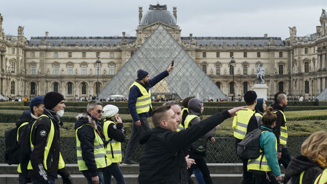Demonstrators march past the Louvre in the latest in the recurring protests. (Photo / AP)