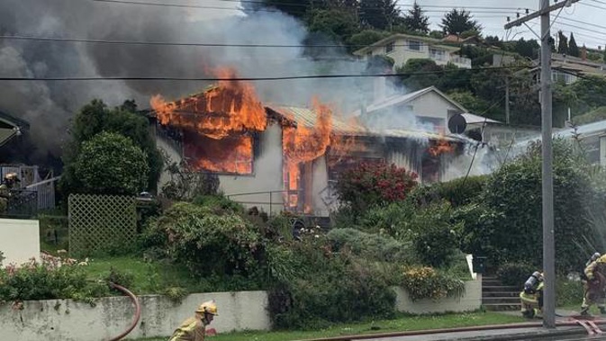 Fire crews work to put out a fire that destroyed a Reed St, Oamaru, home and set alight a neighbouring property yesterday. Photo / Logan Harris