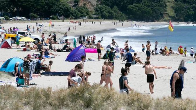 Beachgoers at Mt Maunganui enjoying the traditional blue skies and sunshine. Photo / Alan Gibson