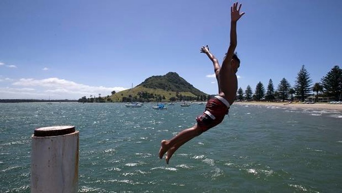 A hot day in the Bay of Plenty spells time for a cooling jump off Salisbury Wharf at Mt Maunganui. Photo / Alan Gibson.