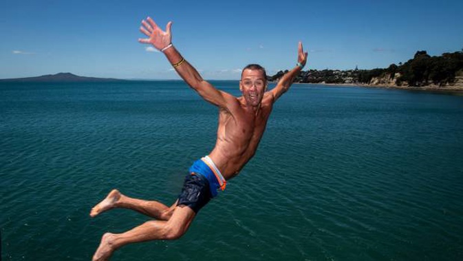 Dale Robinson cools off by jumping into the sea at the Murray's Bay jetty. Photo / Jason Oxenham