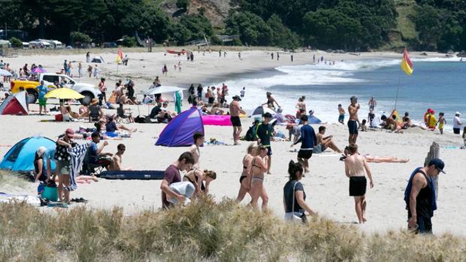 Beachgoers at Mt Maunganui enjoying the traditional blue skies and sunshine Photo / Alan Gibson