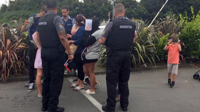 The infamous travellers talk to Police and Immigration officers in Hamilton. (Photo / Belinda Feek)