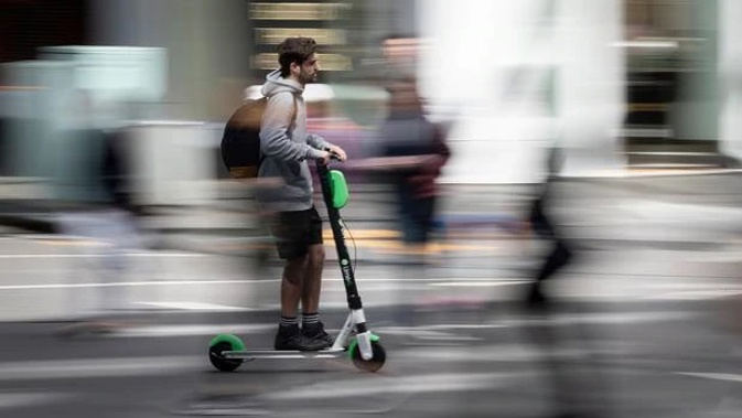 An Aucklander riding a Lime e-scooter around the city. (Photo / Greg Bowker)