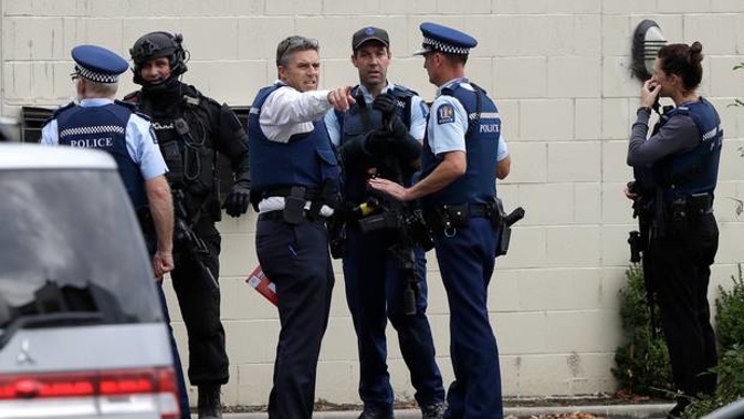 Police stand outside a mosque in central Christchurch following a mass shooting. Photo / AP