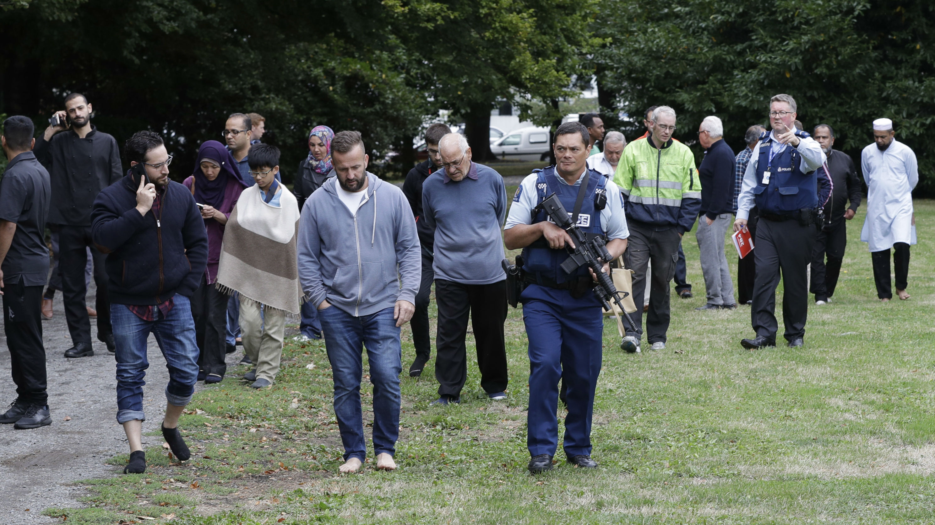 Police protect mosque-goers after the Christchurch terror attack. Photo / AP