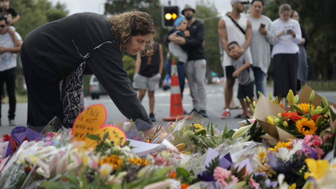 Mourners leave flowers at a memorial for the victims. (Photo / AP)