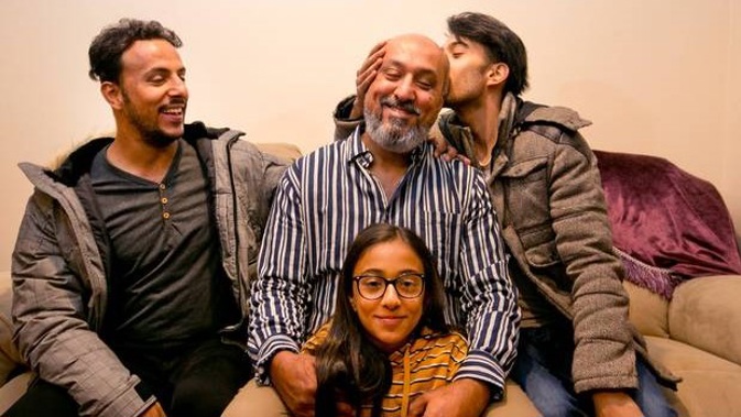 Khaled Al-Jammali gets a kiss from his son, Mahmoud Al-Jammali, right, while his other son, Hamoud Al-Jammali, left, and daughter Tala Al-Jammali are just happy to be with their father.