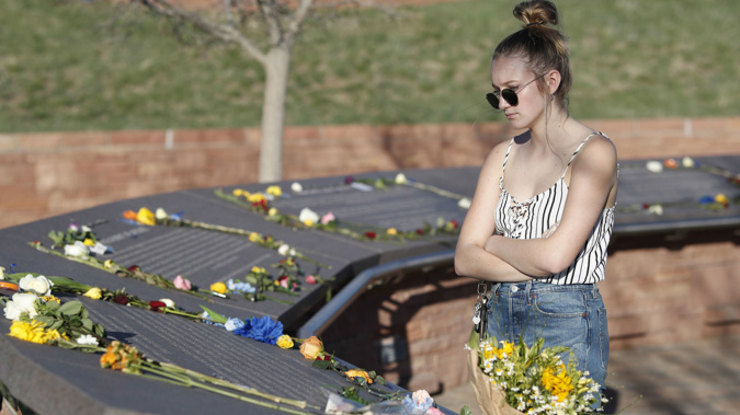 16-year-old Maren Strother looks over the plaques for the victims of the Columbine High School massacre before a vigil at the memorial for the victims of the attack. (Photo / AP)