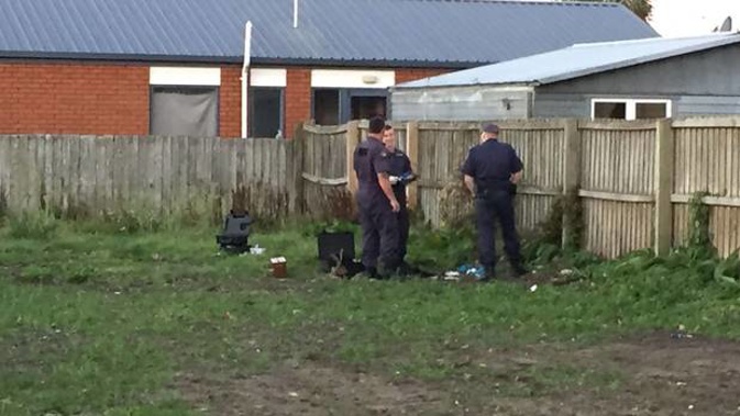 Police focus on a small pile of items on an empty section in Christchurch after responding to a bomb threat. Photo / Kurt Bayer