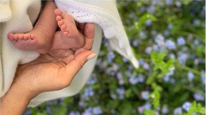 The adorable single image shows the newborn's two tiny wriggling feet being gently held by the Duchess of Sussex's hand. Photo / Instagram. 