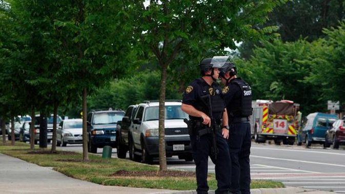 Virginia Beach Police Officers huddle near the intersection of Princess Anne Road and Nimmo Parkway following a shooting at the Virginia Beach Municipal Center. Photo / AP