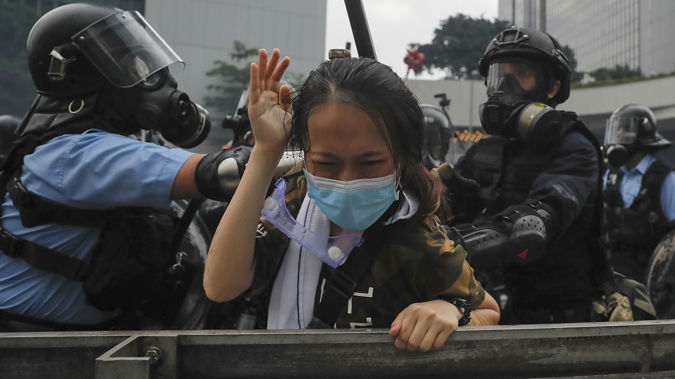A protester in Hong Kong is tackled by police in riot gear. (Photo / AP)