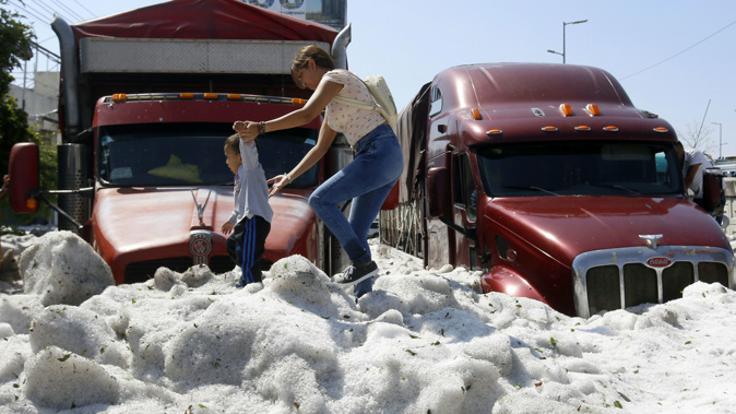 Cars and vehicles were buried beneath the sudden hail. (AFP via CNN)