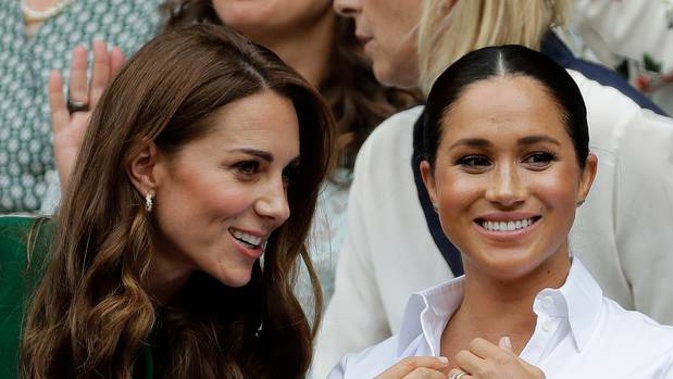 Kate, Duchess of Cambridge, left, and Meghan, Duchess of Sussex chat as they sit in the Royal Box on Centre Court to watch the women's singles final match at Wimbledon. (Photo / AP)