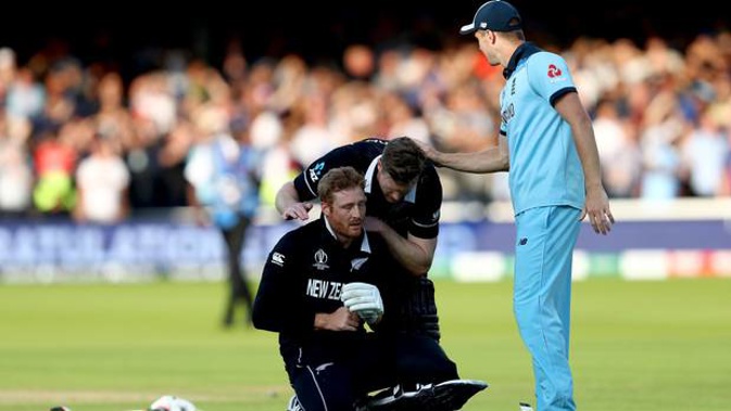 A distraught Martin Guptill is consoled by teammate Jimmy Neesham. (Photo / Getty)